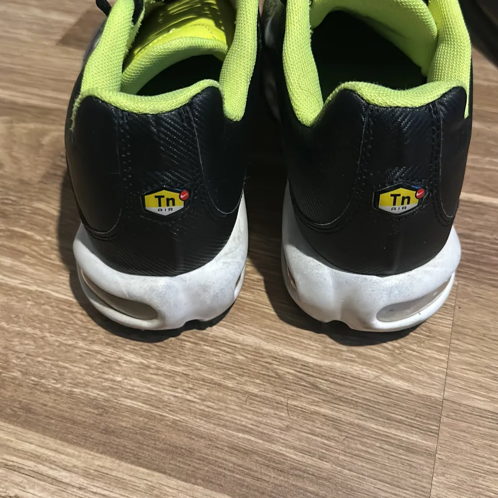 Säljer ett par coola Nike sneakers i svart och neon. De har en unik färgkombination med svart bas och neonfärgade detaljer. Skorna har snörning och en bekväm sula, perfekt för träning eller vardagsbruk. De är i bra skick och redo för nya äventyr!. Skor.