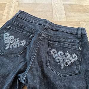 Snygga svarta jeans från Mik Collection i storlek 27. De har ett coolt broderat mönster på bakfickorna Jeansen har en bootcut passform.