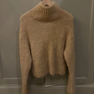 Beige stickad polotröja från & Other Stories - Mysig beige stickad polotröja från & Other Stories. Materialet är ett mohair liknande material. Tröjan har en ribbad polokrage och långa ärmar. Tröjan är aldrig använd och har lappen kvar.❤️