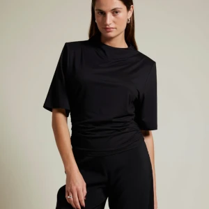 Svart topp med rynkade detaljer - Säljer nu den populära toppen från Bikbok i både svart och vit!🤩Båda är helt oanvända med alla lappar kvar. Köpta för 300kr/st och säljer nu för 200kr/st eller 350kr för båda!🩷