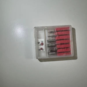 Set med små borrhuvuden - Ett praktiskt set med små borrhuvuden i en genomskinlig plastlåda. Perfekt för precisionsarbete och hobbyprojekt. Innehåller flera olika typer av borrhuvuden för naglar och nagelband.