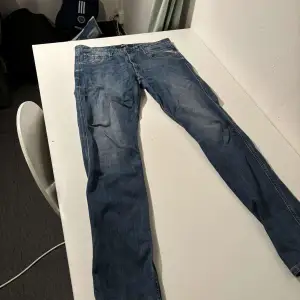 Säljer ett par snygga blå jeans från Replay i bra skick. De har en klassisk femficksdesign och är tillverkade i slitstarkt denim. Storleken är 31 i midjan och 34 i längd. 