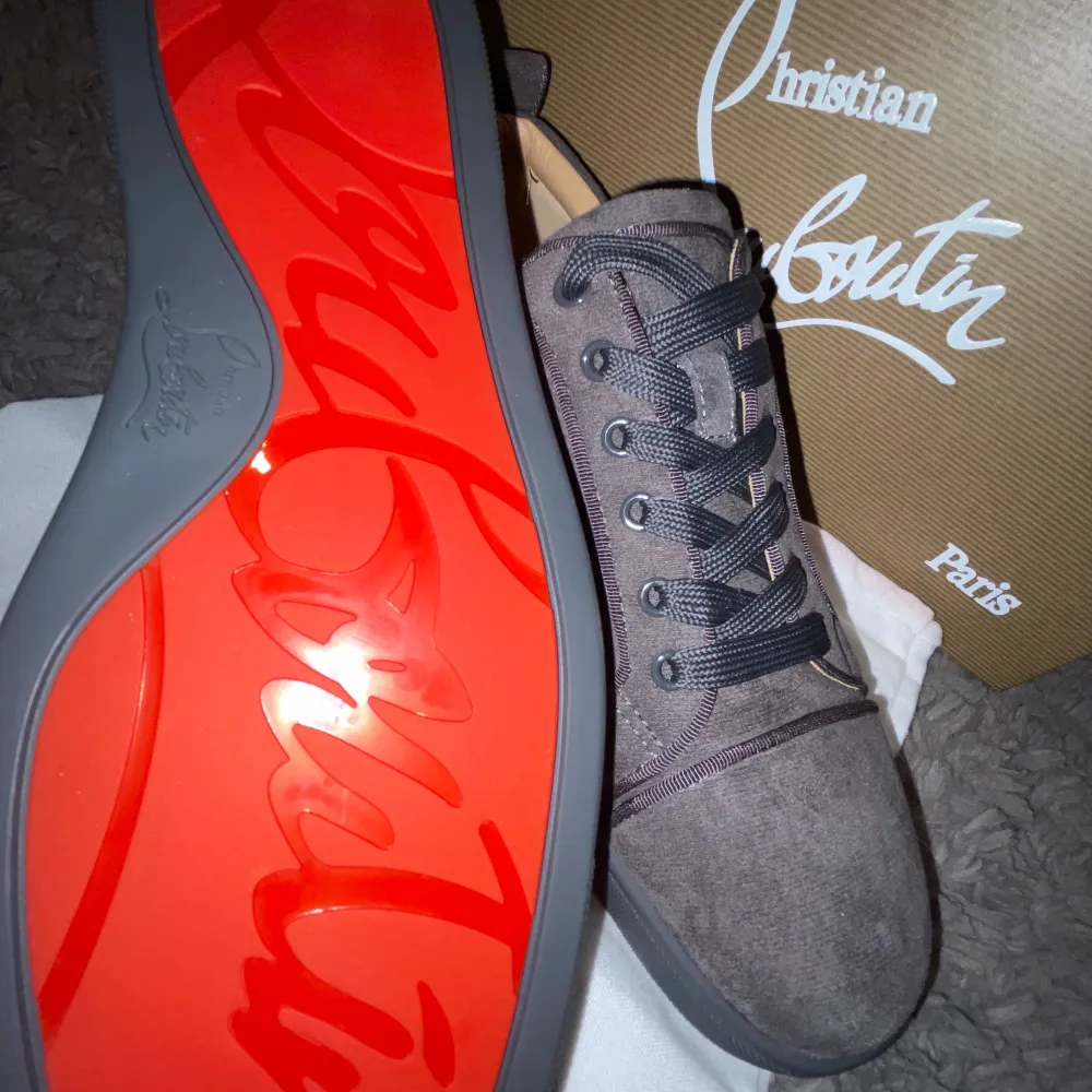 Säljer ett par snygga grå sneakers i mocka från Christian Louboutin. De har den ikoniska röda sulan och klassisk snörning. Perfekta för både vardag och fest! Skorna är i nytt skick och kommer med originalförpackning och tillbehör.. Skor.