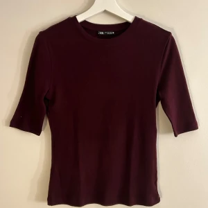 Zara tröja - Säljer denna super söta vinröda topp från Zara i nytt skick. Den har trekvartsärm och är gjord i ett mjukt material som känns skönt mot huden. Passar till allt! Helt ny och inga defekter! ❣️❣️❣️Skulle säga att den passar för någon som har Xs/S/M! 