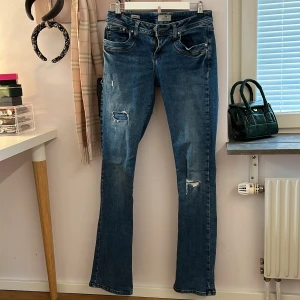 Blå jeans från LTB - Säljer ett par snygga blå lågmidjade och bootcut jeans från LTB i modellen Valerie och storlek W27 L34. De är lite slitna längst ner på ena benet som man ser på bilden. Säljer då de inte kommer till användning.💕