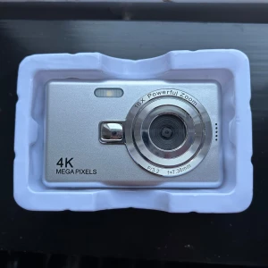 Digitalkamera  - Helt ny digitalkamera som inte kommer till användning. Perfekt för resor eller utekvällar! Minneskort, laddare, och snöre till kameran medföljer. 