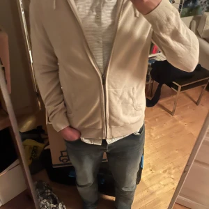 Beige hoodie från kapphal - Säljer en snygg beige hoodie från kapphal i bra skick. Den har dragkedja framtill och en klassisk passform. Perfekt för både vår och höst. Passar till det mesta och är superbekväm!