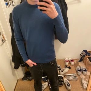 Blå tröja i bomull - Säljer en stilren blå tröja i bomull. Perfekt för både vardag och lite finare tillfällen. Tröjan har en normal passform och långa ärmar, vilket gör den idealisk för höst och vår. Nypris ligger runt 800 kr. Den är i mycket bra skick och redo för en ny ägare. Priset går såklart att diskutera!