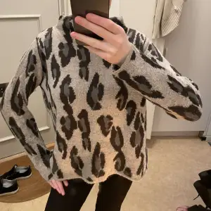 Säljer en supercool beige tröja med leopardmönster. Den är perfekt för höst och vinter med sin mysiga stickade kvalitet. Tröjan har långa ärmar och en avslappnad passform som gör den både bekväm och trendig. Perfekt för att liva upp din garderob! Sparsamt använd så imprincip nyskick 💕 passar mig som brukar ha XS och S!