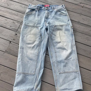 Surpeme double knee jeans - Otroligt feta supreme double knee painter jeans med en ”light wash” från S/S 23 köpta i supreme butiken i Milano så påse och fysiskt kvitto finns, dom är ganska använda men ändå i bra skick, men uppsydda 2cm. Nypris nu~ 2800