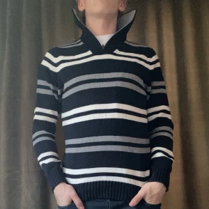 Randig stickad tröja - Säljer en snygg randig stickad tröja i svart, grått och vitt. Den har en hög krage och långa ärmar, perfekt för kyliga dagar. Tröjan är i bra skick och passar både till vardags och lite finare tillfällen. Vid minsta fråga eller fundering hör av er🤝