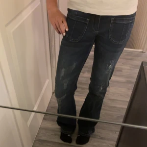 Mörkblå jeans med slitningar - Säljer ett par mörkblå jeans i nytt skick. De har snygga slitningar på framsidan och en klassisk femficksdesign. Perfekta för en avslappnad vardagslook. Passar bra till både sneakers och boots. Jeansen fick jag i julklapp och har aldrig använts❤️