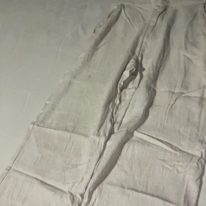 Beige linnebyxor från Grunt - Säljer ett par bekväma beige linnebyxor från Grunt i storlek L fast nu så passar de bäst i storlek M även S. Perfekta för sommaren med sin lätta och luftiga känsla. Byxorna har en elastisk midja för extra komfort och två bakfickor. De är i bra skick och redo för nya äventyr! Ordinare pris 700kr