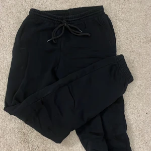 Svarta mjukisbyxor med snörning - Säljer ett par svarta mjukisbyxor i bra skick. De har en bekväm passform med snörning i midjan för justerbarhet. Perfekta för en avslappnad dag hemma eller en snabb tur till affären. Passar till alla säsonger och är ett måste i garderoben!