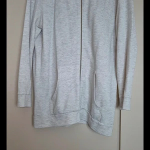 Beige zip-hoodie från Monki - Säljer en supermjuk och bekväm beige zip-hoodie från Monki i storlek Large. Den har långa ärmar och praktiska fickor framtill. Perfekt för en avslappnad stil eller mysiga dagar hemma. Dragkedjan gör den enkel att ta på och av. Passar perfekt till höst och vår!