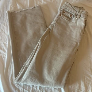Beige jeans med rå kant - Säljer ett par snygga beige jeans med rå kant. De har en normal passform och är perfekta för en avslappnad stil. Jeansen har klassiska fem fickor och en knappgylf. Perfekta för både vardag och fest!