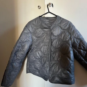 Grå quiltad jacka från MNG - Säljer en snygg grå quiltad jacka från MNG i storlek M. Perfekt för höst och vår när du vill hålla dig varm men ändå se stilren ut. Passar både till vardags och lite finare tillfällen.