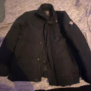 Svart jacka från Polo Club - Säljer en svart jacka från Polo Club i storlek L. Den har en broderad logga på ärmen och stängs med dragkedja och knappar. Perfekt för höst och vinter med sin varma och stilrena design. Passar både till vardags och lite finare tillfällen.