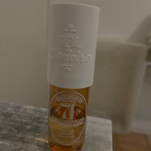 Parfym Sol de Janeiro Cheirosa '71 - Säljer en härlig parfym från Sol de Janeiro, Cheirosa '71. Flaskan är genomskinlig med en vit kork och har en varm, gyllene vätska inuti. Doften är söt och krämig med inslag av karamell och macadamia. Perfekt för dig som älskar gourmand-dofter! 🧡Använt halva doften:)