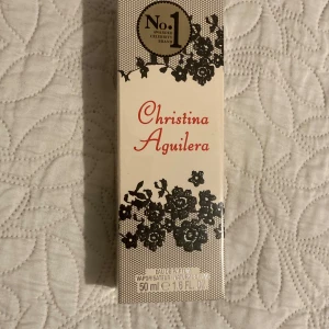 Parfym Christina Aguilera - Säljer  parfym från Christina Aguilera. Flaskan rymmer 50 ml och doften är en härlig blandning av pioner och jasmin med en krämig vaniljton. Förpackningen är stilren med svart spetsdesign mot en vit bakgrund. Perfekt för både vardag och fest!