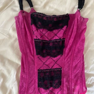 Rosa korsett - Jättesnygg rosa korsett, knäppning med hyskor där bak. Storlek XS-S. Köpt second hand. Justerbara axelband💕