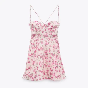 Blommig klänning från Zara - Jättefin blommig klänning från zara som inte säljs längre. Säljer bara pga att jag inte kan ha den då den är för kort. Färgen är något mer rosa än på de första bilderna. Snörning baktill