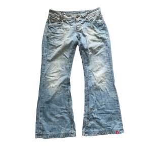 Stylish bootcut jeans in a light blue wash with distressed details. • Waist: 37-38 cm • Inseam: 93 cm • Leg opening: 27 cm