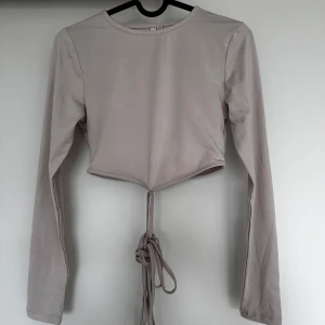 Tröja/topp - Topp ifrån Nelly med knytning som man knyter runt magen och bak på ryggen💕 Stl: xs🫶🏽