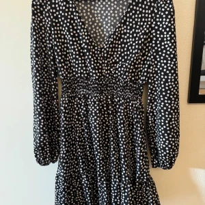 Svart blommig klänning - Svart långärmad sommarklänning med vita blommor, ej använd