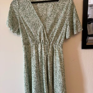 Grön sommarklänning - En grön sommarklänning med söta blommor på, ej använd