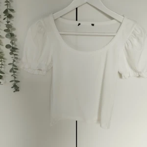 Vit Puff-Ärmad T-skjorta - En vit ribbad tröja (Puff-Ärmad, T-skjorta) för kvinnor. Etiketten togs tyvärr bort men är medveten om att storleken är S. Skönt material helt oanvänd, nyskick. 