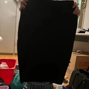 Svart kjol från Amisu - Säljer en stilren svart kjol från Amisu i storlek 36. Kjolen är perfekt för både vardag och fest och har en klassisk design som aldrig går ur tiden. Den är gjord i ett bekvämt material som sitter snyggt på kroppen.