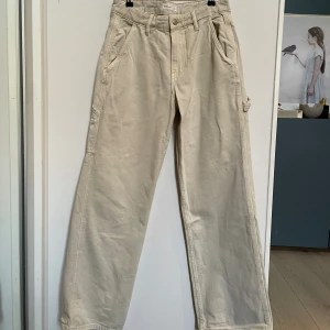 Ginatricot Cargo jeans  - Ett par beiga jeans med cargo detaljer. Mellan hög midja. Aldrig använda.