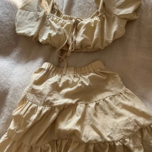 Tvådelat fint set - Säljer detta settet. Inte kommit så mycket till användning, därför säljer jag det. Toppen är ganska kort så men kjolen är ganska hög i midjan så de väger upp. Jättefint nu till sensommaren. 