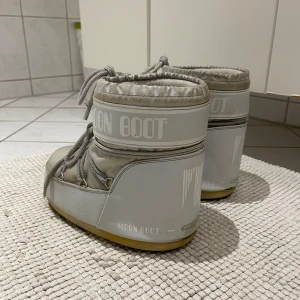 Moon boot - Låga Moonboots gråa, använda en vinter. De är i bra skick förutom att de är lite smutsiga (lätt att rengöra och kan göra det om det önskas) och de är lite spruckna där bak därav priset, men Inget som man tänker på (se bild 3). De är i storlek 39-41