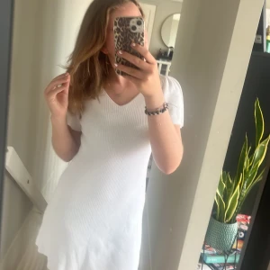 Vit ribbad klänning från ONLY - Säljer en superfin vit ribbad klänning från ONLY i storlek XS. Den har en v-ringad hals och korta ärmar, perfekt för sommardagar. Klänningen har en söt knytning i ryggen som ger en extra detalj. Passar både till vardags och festliga tillfällen! aldrig använd och prislappen är fortfarande kvar❤️