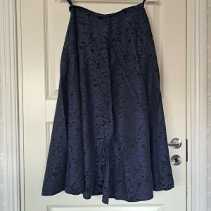 Lång blå kjol - Säljer nu min favorit kjol då den blivit för liten. Mönstrad svart och blå kjol med fickor. Uppskattad storlek S/M.