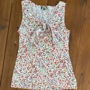 Blommig linne med Knyt detalj fram till. - Sommrigt  linne från bikbok i storlek XS!