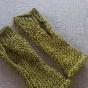 Stickade gröna handledsvärmare - Säljer ett par handstickade gröna handledsvärmare. De är handgjorda med ett fint mönster och har en härlig olivgrön färg. Perfekta för att hålla händerna varma under kyliga dagar utan att begränsa fingrarnas rörelse. Passar bra till höst- och vinteroutfits!