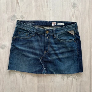 Lågmidjad jeanskjol från Replay - Lågmidjad jeanskjol från Replay som jag har gjort om från en längre kjol. Fint skick. Storlek W28 och jag skulle säga att den passar både S och M. Tvärs över midjan är det 39 cm och längs med sidan är det 32 cm. Använd gärna köp nu!