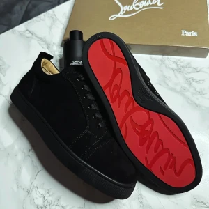 Går ej att köpas längre, finns redan någon Svarta oanvända Louboutin 100% kvalité spikeless  - Kan skickas inom 2 veckor pga är på semester. 100% kvalité. Snygga svarta sneakers från Christian Louboutin med den ikoniska röda sulan. Skorna har en stilren design med snörning och är tillverkade i skinn. Perfekta för den som vill ha en lyxig touch i vardagen