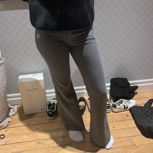 Grå byxor med bootcut - Snygga grå byxor med bootcut-stil. De har en tight passform upptill och vidgar sig nedtill för en trendig look. Perfekta för en stilren outfit.