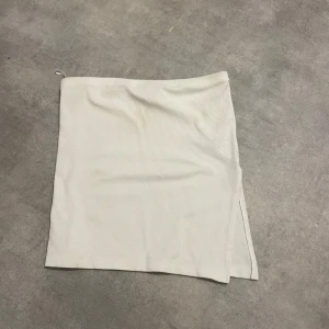 Vit ribbad topp från Nelly - Snygg vit ribbad topp från Nelly. Toppen har en stilren design med en liten slits på sidan som ger en extra touch. Skriv vid frågor🫶🏻