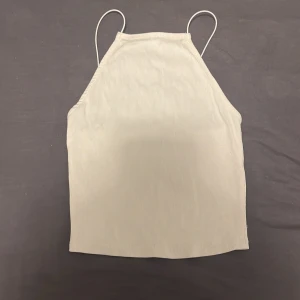 Vit ribbad linnetopp - Snygg vit ribbad linnetopp med smala axelband. Storlek M men passar även S. Perfekt för varma dagar och enkel att matcha med olika outfits.