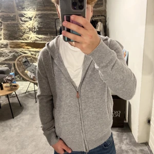 Grå Kashmir hoodie från Sayless - Mysig grå hoodie från Sayless i kashmir. Den har en dragkedja framtill och en justerbar huva med snören. Perfekt för kyligare dagar. Skick 8/10 lite nopprig men går lätt att lösa, nypris 899kr mitt pris 450 men går självklart att diskutera👍🏽
