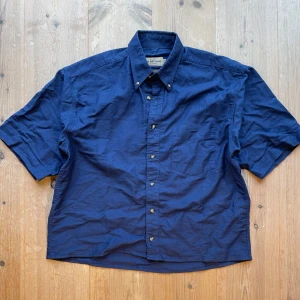 Blå kortärmad skjorta från The Browns - Säljer en klassisk blå kortärmad skjorta från The Browns i prewashed bomull. Skjortan har knappar framtill och en bröstficka. Perfekt för en avslappnad stil. Kroppad och boxy ditt som vi alla älskar. Storlek M, skriv vid frågor!