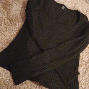 Svart ribbad tröja - Snygg svart ribbad tröja med långa ärmar. Perfekt för kyligare dagar och enkel att matcha med olika outfits.