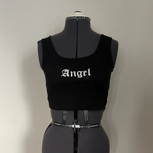 Svart crop top med text - Svart croppad topp med texten 'Angel' i vitt.