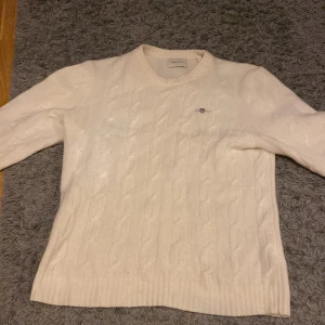 Vit stickad tröja från Gant - Säljer min stilrena kashmir tröja av lammull från Gant då den blivit för liten för mig. Tröjan har endast blivit använd 5-10 gånger då jag tappade bort den under ett tag (den låg längst ned i lådan😅) Tröjan är krämvit och riktigt fräsch till i princip alla outfits! Köpte på Johnells för ca 1500kr, men nu är nypris ~1200kr😁 Pris går att diskutera- men vill inte ha några skambud.