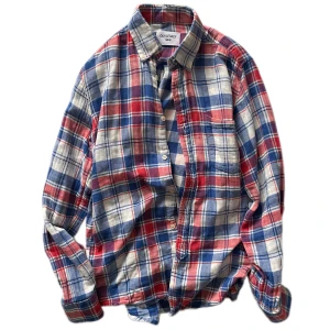 Our Legacy skjorta  - Säljer en snygg rutig skjorta från Our Legacy i rött, blått och vitt. Skjortan är tillverkad i 100% bomull och har långa ärmar med knappar framtill. Perfekt för en avslappnad stil. Tveka inte med att buda!